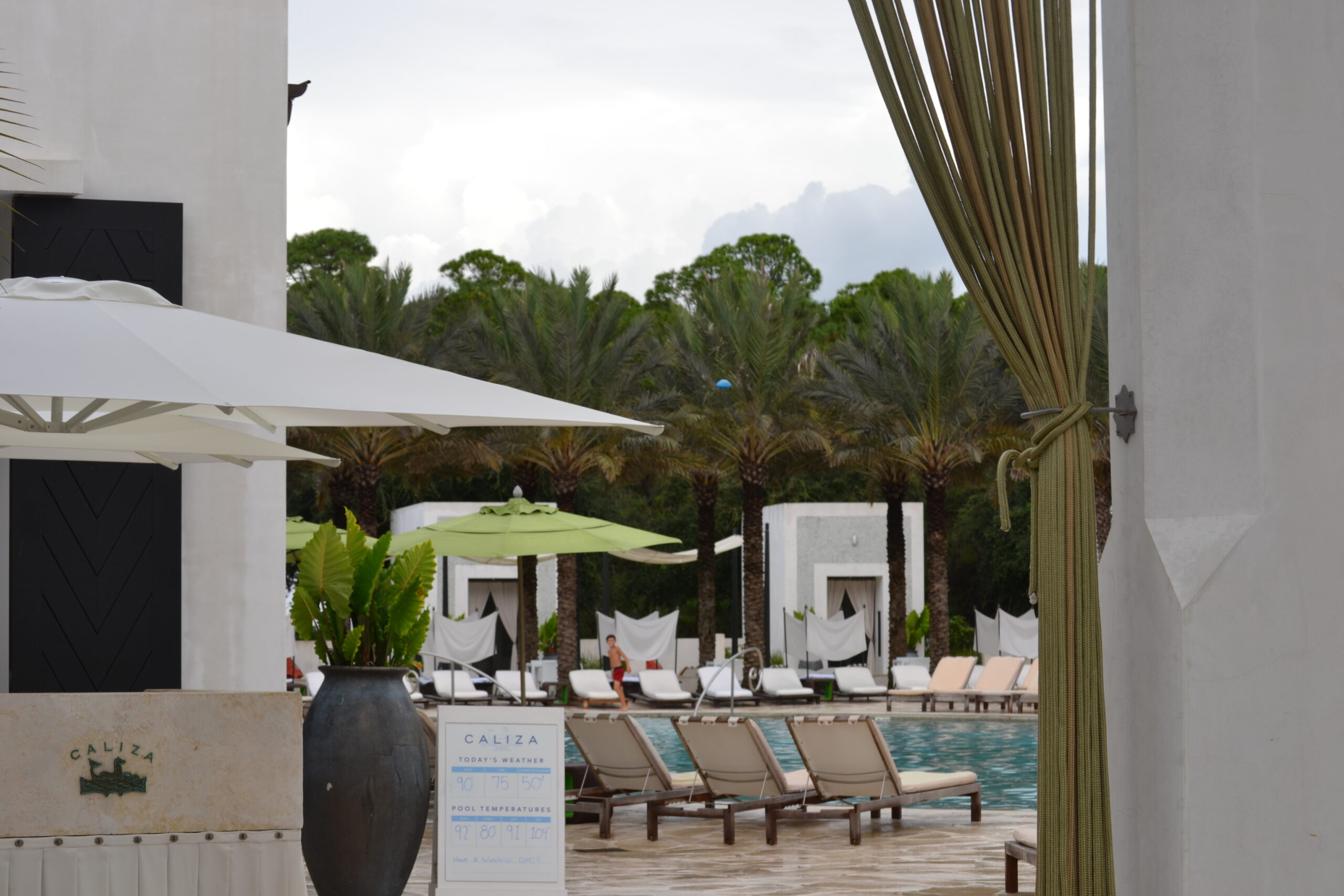 The Caliza pool at Alys Beach with cabanas and palm trees