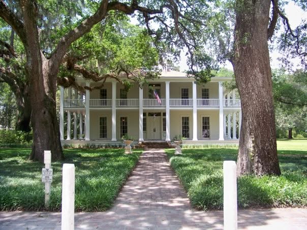 The white-columned Wesley homestead at Eden Gardens State Park beneath moss-draped live oaks