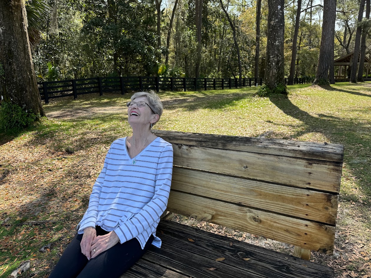 Eden Garden State Park. Elderly lady sitting on a bench under the oaks.