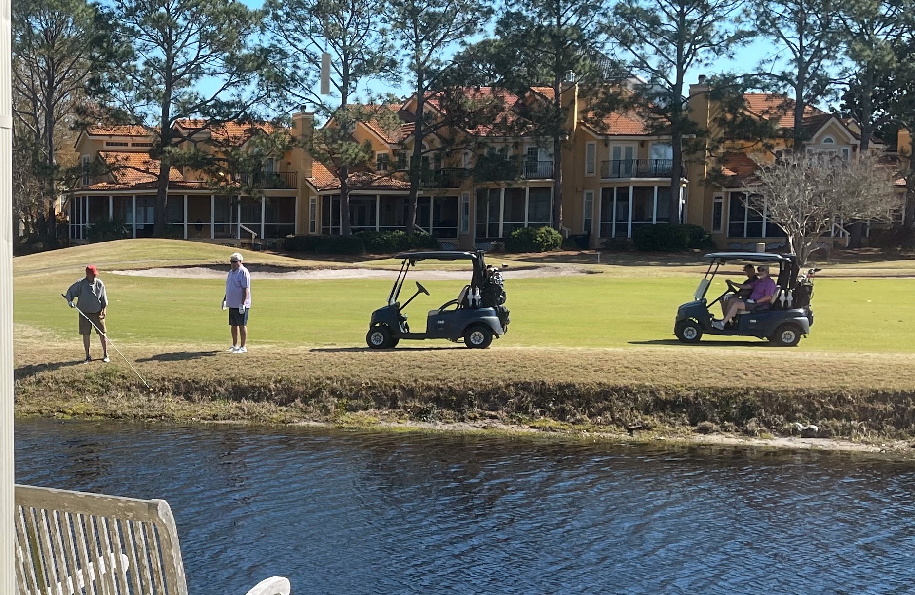 Miramar Beach, Sunny Day, People playing Golf, townhomes in background.