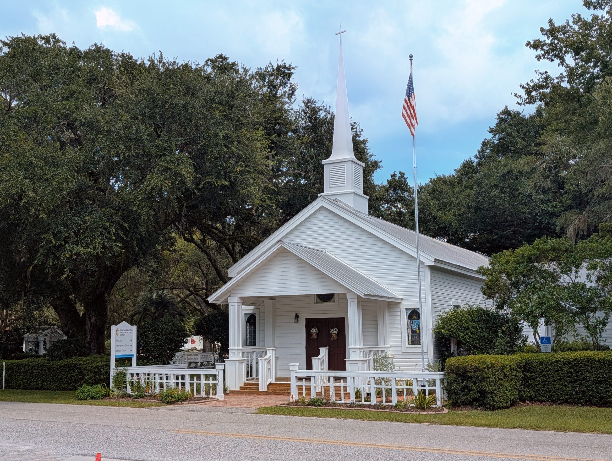 A historic white wooden church under mature trees in Point Washington, Florida